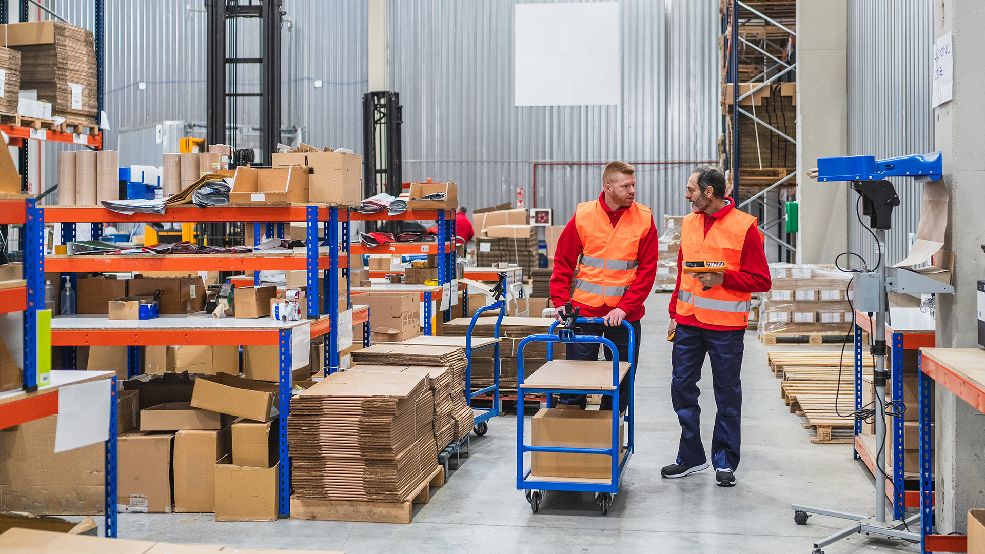 Dwóch mężczyzn podczas prac magazynowych.