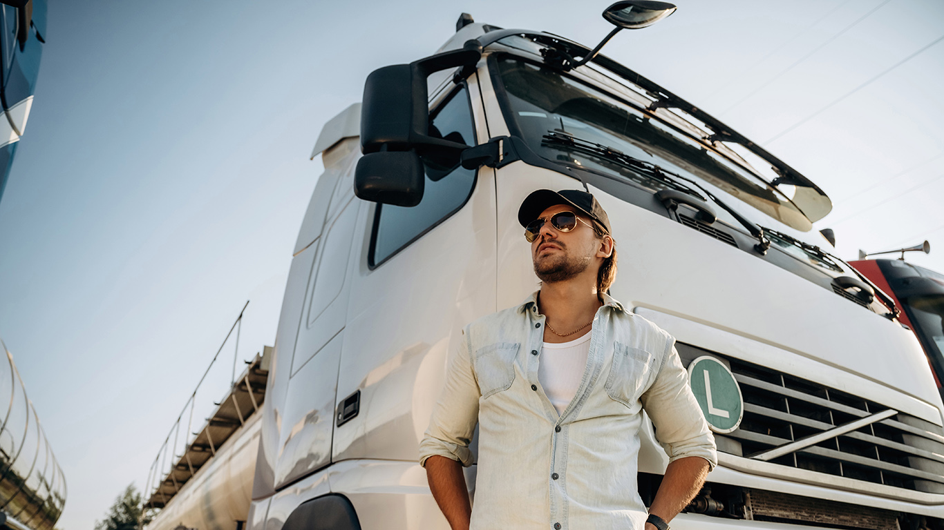 Kierowca znajdujący się w pobliżu auta ciężarowego.