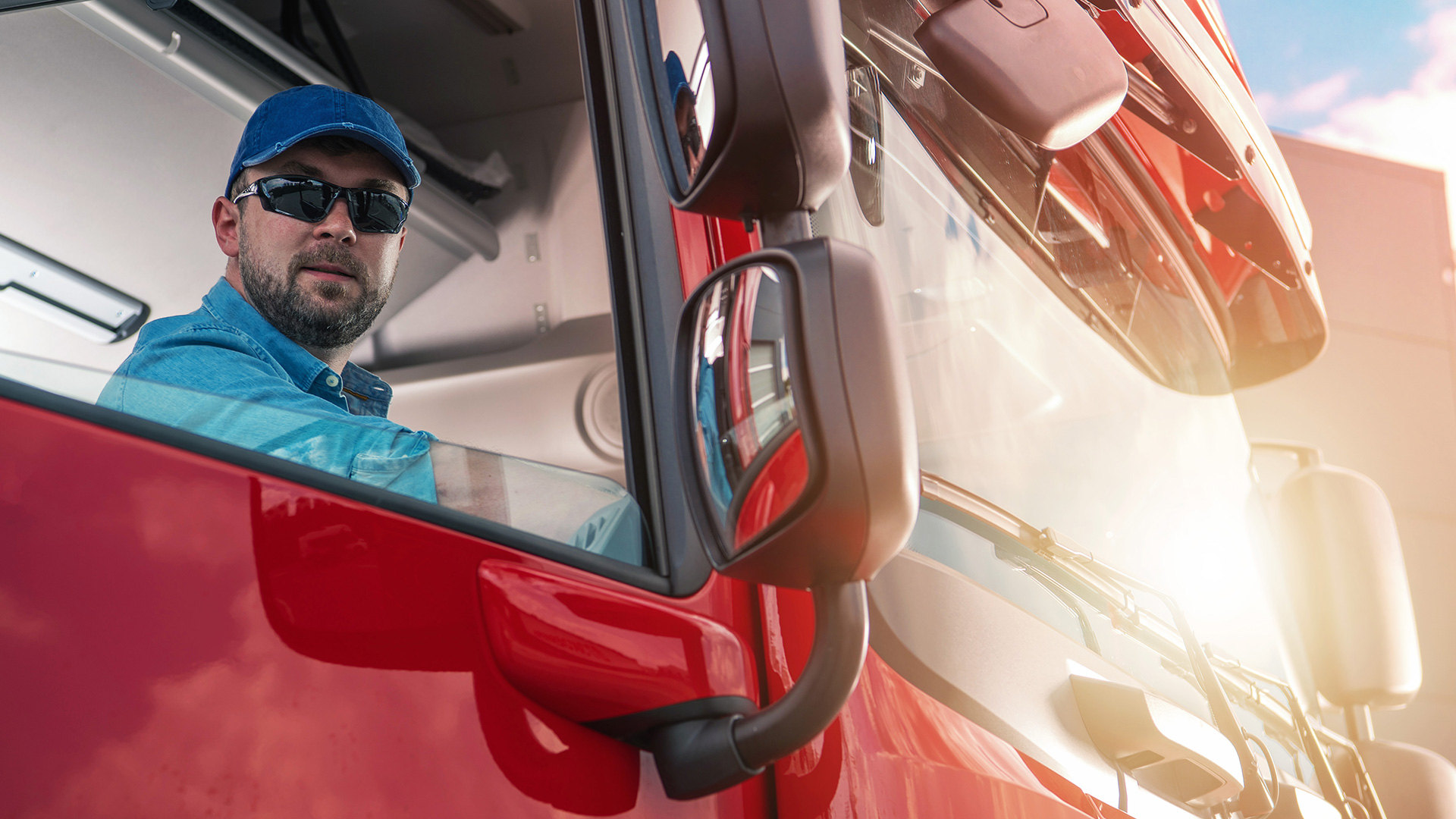 Mężczyzna siedzący w ciągniku siodłowym.