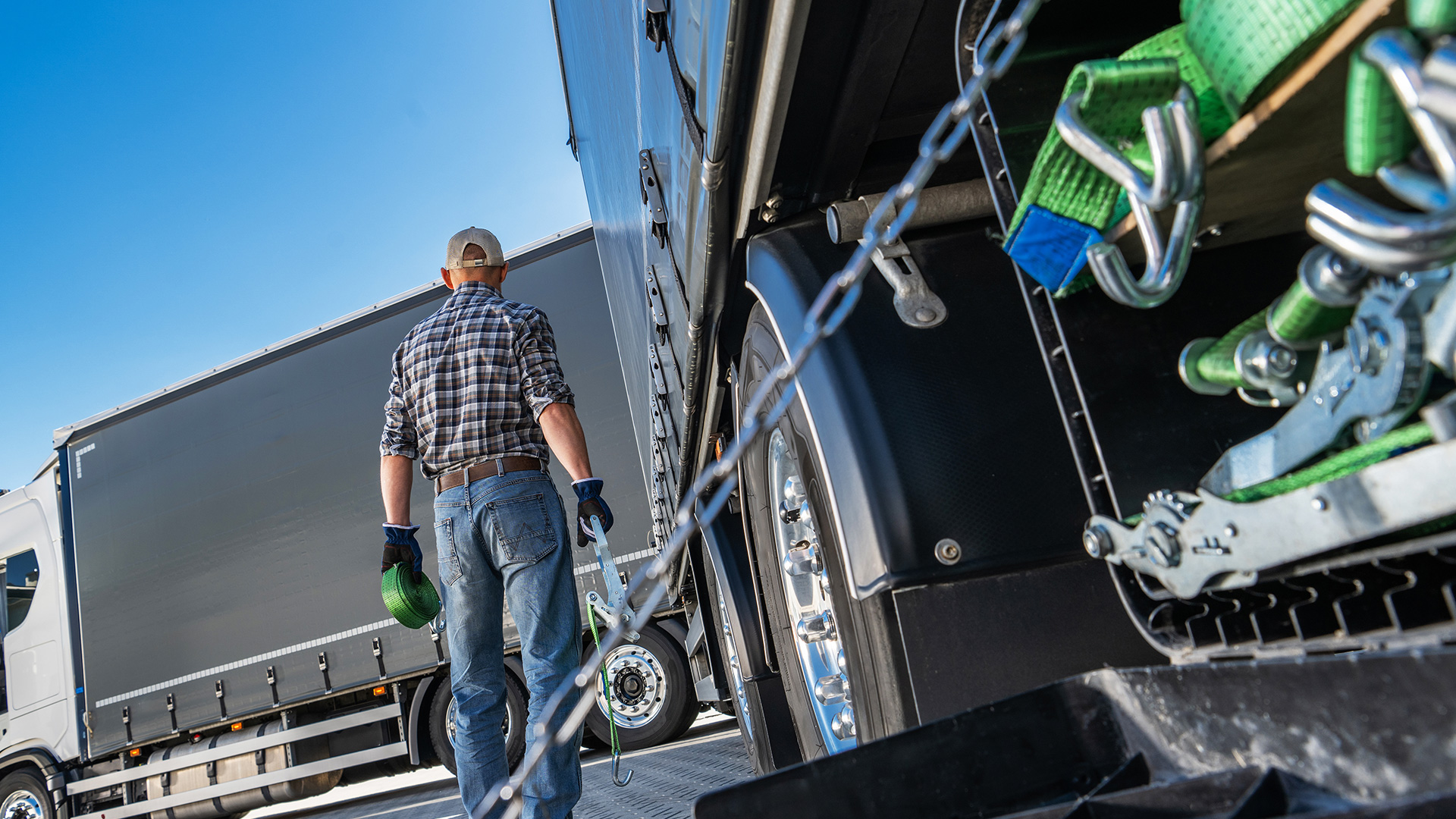 Mężczyzna zabezpieczający ładunek w naczepie.