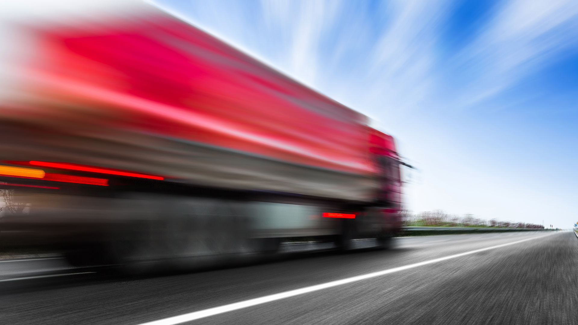 Czerwona ciężarówka w trasie.