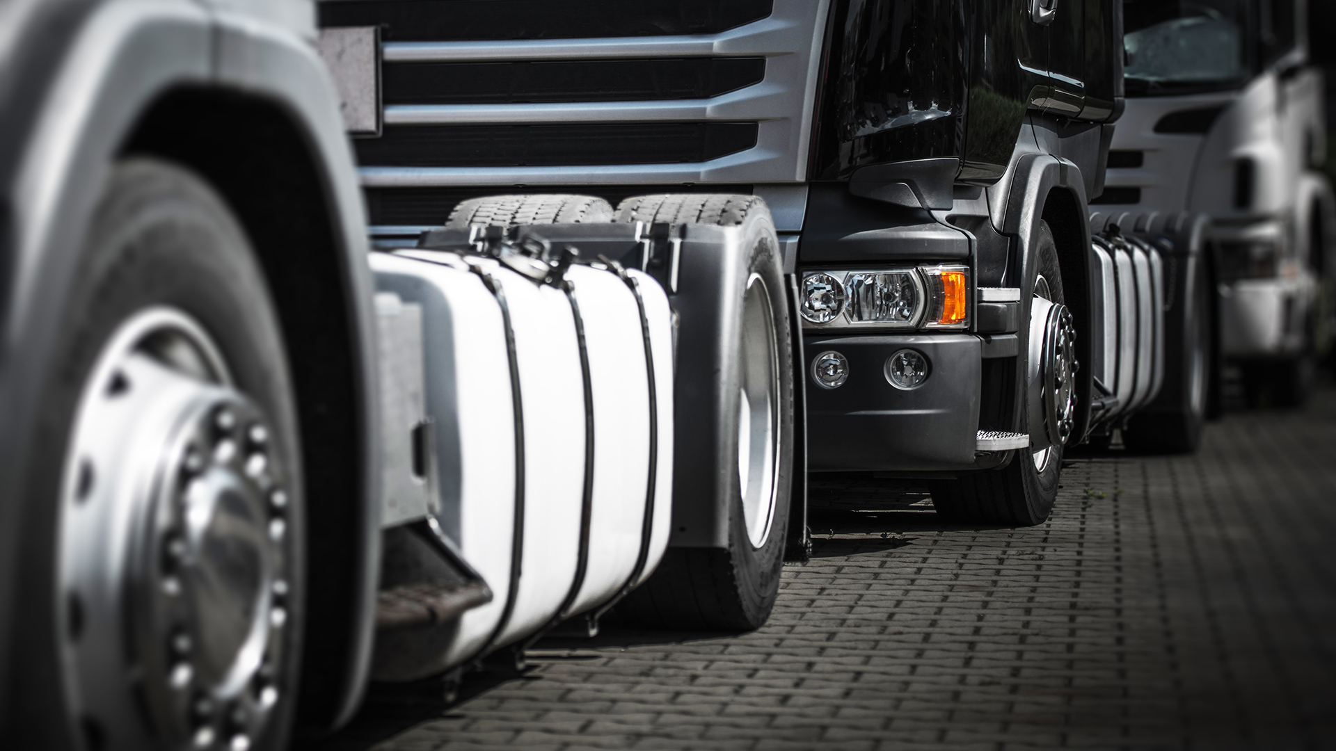 Auta ciężarowe stojące w korku.