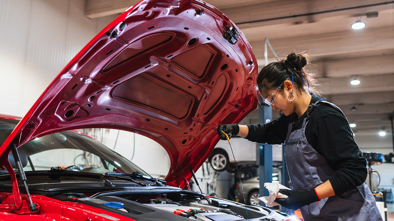 Kobieta podczas inspekcji auta osobowego.