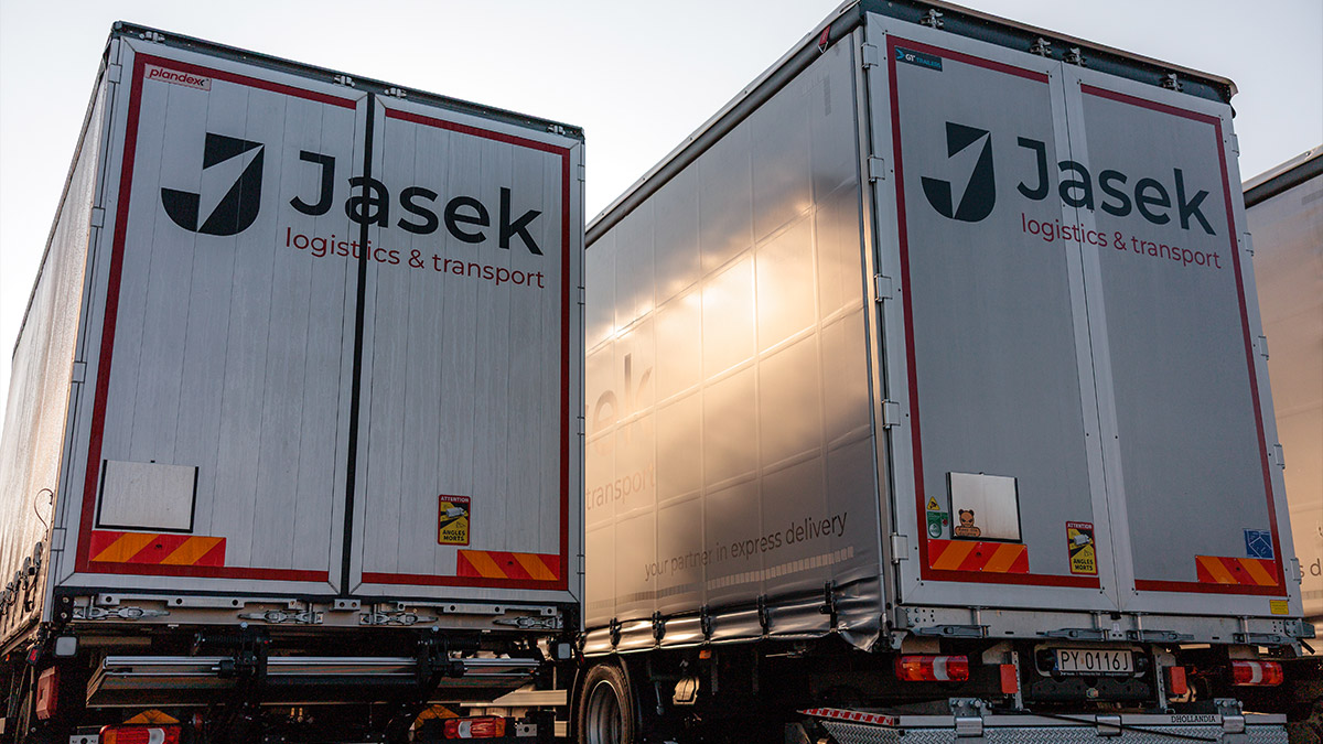 Zbliżenie na tył naczep dwóch aut ciężarowych.